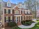 Elegant two-story brick home featuring dormer windows, a manicured lawn, and mature landscaping at 5816 Sand Pebble Pl, Raleigh, NC 27613