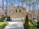 Side view of home showing a two-car garage, concrete driveway and mature trees at 5816 Sand Pebble Pl, Raleigh, NC 27613
