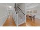 Hallway with hardwood floors and staircase that leads to dining room with a table at 5816 Sand Pebble Pl, Raleigh, NC 27613