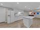 Basement kitchen with white cabinets, an island and a full-sized refrigerator at 5816 Sand Pebble Pl, Raleigh, NC 27613