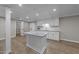 Basement kitchen with white cabinets, an island and a full-sized refrigerator at 5816 Sand Pebble Pl, Raleigh, NC 27613