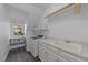 Well-lit laundry room with modern appliances, ample counter space, and storage shelves at 5816 Sand Pebble Pl, Raleigh, NC 27613
