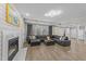Spacious living room with a fireplace, gray sectional couch, and abundant natural light at 5816 Sand Pebble Pl, Raleigh, NC 27613