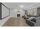 Cozy living room features a gray sectional couch, fireplace, and large media screen at 5816 Sand Pebble Pl, Raleigh, NC 27613