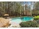 Pool area featuring lounge chairs and a tropical umbrella in a private yard at 5816 Sand Pebble Pl, Raleigh, NC 27613