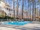 Backyard pool and patio surrounded by lush greenery, woods, and plenty of seating at 5816 Sand Pebble Pl, Raleigh, NC 27613