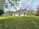 Expansive backyard with a lush lawn, mature trees, and outbuilding, creating a serene and private outdoor space at 5920 Holly Dr, Raleigh, NC 27616