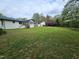 A lush backyard, highlighting the spacious lawn, mature trees, shed, and the home's inviting exterior at 5920 Holly Dr, Raleigh, NC 27616