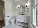 Bathroom features a white vanity, black fixtures and a window overlooking the front yard at 5920 Holly Dr, Raleigh, NC 27616