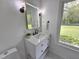 Bathroom features a white vanity, black fixtures and a window overlooking the front yard at 5920 Holly Dr, Raleigh, NC 27616