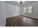 Bright, airy bedroom with hardwood floors, fresh paint, and new light fixture at 5920 Holly Dr, Raleigh, NC 27616