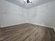 Minimalist bedroom with dark wood floors, white walls, and modern lighting at 5920 Holly Dr, Raleigh, NC 27616