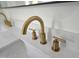 Close up of elegant gold faucets and countertop in a renovated bathroom at 5920 Holly Dr, Raleigh, NC 27616