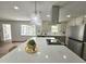 Modern kitchen with stainless steel appliances, island cooktop, and stylish range hood at 5920 Holly Dr, Raleigh, NC 27616