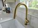 Close-up of a modern gold faucet over a white kitchen sink and white backsplash at 5920 Holly Dr, Raleigh, NC 27616
