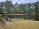 Picturesque lake view with a wooden dock and lush greenery, perfect for nature enthusiasts at 5920 Holly Dr, Raleigh, NC 27616