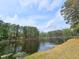 Breathtaking lake view reflecting the sky, surrounded by tall pine trees and natural landscape at 5920 Holly Dr, Raleigh, NC 27616
