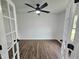 Office space featuring vinyl floors and ceiling fan, framed by stylish french doors with black hardware at 5920 Holly Dr, Raleigh, NC 27616