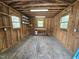 The interior of the outbuilding with wood paneled walls, windows, shelving and workbench at 5920 Holly Dr, Raleigh, NC 27616