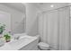 Clean bathroom with white cabinets, modern fixtures, and a shower-tub combination with a white curtain at 6309 Truxton Ln, Raleigh, NC 27616