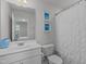 Well-lit bathroom with white vanity, toilet, and a mirror reflecting the bedroom at 6309 Truxton Ln, Raleigh, NC 27616