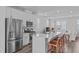 Bright open-concept kitchen featuring white cabinets, stainless steel appliances, and a large island with seating at 6309 Truxton Ln, Raleigh, NC 27616