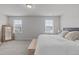 A bright main bedroom with a wooden bench at the end of the bed and view of neighborhood outside windows at 6309 Truxton Ln, Raleigh, NC 27616