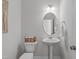 A simple powder room with a pedestal sink and wall mirror at 6309 Truxton Ln, Raleigh, NC 27616