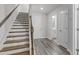 Staircase leading to upper floors with hardwood steps, white risers, and an ornate banister at 6309 Truxton Ln, Raleigh, NC 27616