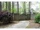 Backyard with a wooden fence, brick path, and lush landscaping leading to a charming home at 6417 Meadow View Dr, Raleigh, NC 27609