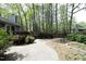 A backyard featuring a patio with a deck, lush plantings, and beautiful mature trees at 6417 Meadow View Dr, Raleigh, NC 27609