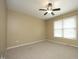 A bright bedroom features neutral walls, carpet, ceiling fan, and window for natural light at 6417 Meadow View Dr, Raleigh, NC 27609