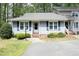 Charming home featuring blue siding, black shutters, lovely lawn and paved drive at 6417 Meadow View Dr, Raleigh, NC 27609