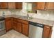 View of the kitchen sink and stainless steel dishwasher with granite countertops and tile backsplash at 6417 Meadow View Dr, Raleigh, NC 27609