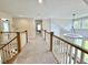 Upstairs hallway featuring carpeted floors, a modern light fixture, and views of the living area below at 6521 Camellia Creek Dr, Raleigh, NC 27603