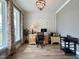 Stylish home office featuring a large window, modern lighting, and wood-look flooring at 6521 Camellia Creek Dr, Raleigh, NC 27603
