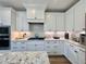 Modern kitchen features white cabinets, granite countertops, and stainless steel appliances at 6521 Camellia Creek Dr, Raleigh, NC 27603