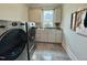 Modern laundry room featuring a front load washer and dryer, gray cabinets, and sink at 6521 Camellia Creek Dr, Raleigh, NC 27603