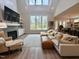 Open concept living room showcasing a fireplace, large windows, and modern decor at 6521 Camellia Creek Dr, Raleigh, NC 27603