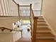 Open staircase leading to a well-lit living area with hardwood floors and neutral furnishings at 6521 Camellia Creek Dr, Raleigh, NC 27603
