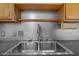 Close up of kitchen sink with a stainless steel faucet and wood cabinets at 700 Market St # 214, Chapel Hill, NC 27516