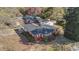 Aerial view of red brick single story house, detached garage, mature trees and landscaping on an over cast day at 706 Forest Dr, Garner, NC 27529