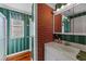 Bathroom with vertical striped wall paper and a red brick accent wall at 706 Forest Dr, Garner, NC 27529