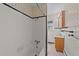Tidy bathroom features a shower/tub combo, patterned wallpaper, vanity sink, and tiled walls at 706 Forest Dr, Garner, NC 27529