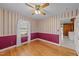 Cozy bedroom with hardwood floors, two-tone walls, ceiling fan, and two windows at 706 Forest Dr, Garner, NC 27529