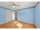 Bright blue bedroom featuring hardwood floors, closet doors, and sunlight streaming in from the window at 706 Forest Dr, Garner, NC 27529