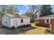 Spacious detached garage with lawn and mature plantings on a sunny day beside the house at 706 Forest Dr, Garner, NC 27529