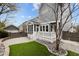 Home's backyard shows a manicured lawn, stone patio, screened in porch and beautiful landscaping at 711 Virginia Ave, Raleigh, NC 27604