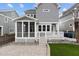 Home's backyard shows a manicured lawn, stone patio, screened in porch and beautiful landscaping at 711 Virginia Ave, Raleigh, NC 27604