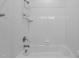 Relaxing tub and shower featuring a white tile surround with a sleek shower fixture at 711 Virginia Ave, Raleigh, NC 27604
